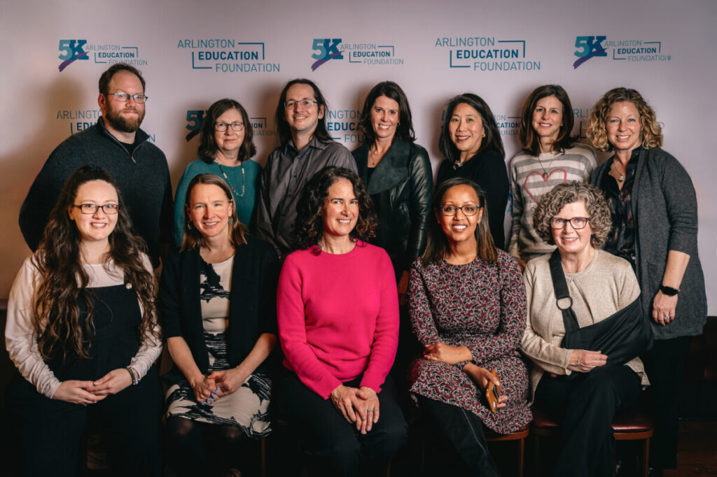 group of board members standing in front of a step and repeat wall.