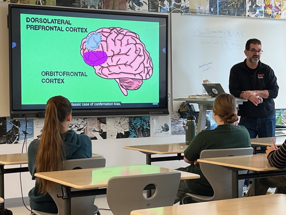 Michael Sandler teaches his psychology class in front of a screen showing the regions of the brain