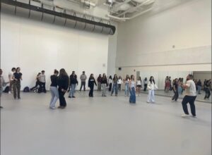 Students leaning to dance in a gym environment